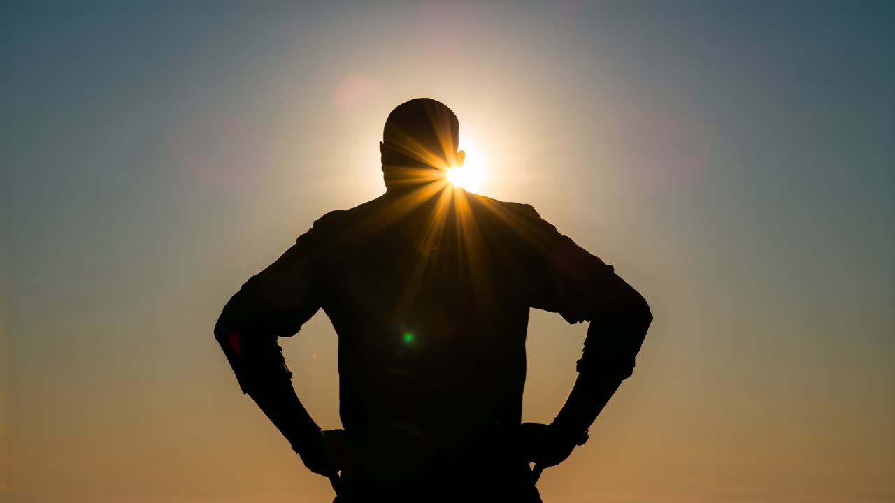 Uomo in piedi in silhouette che osserva il sole muoversi dietro la testa all'orizzonte, indossando una giacca tra un bagliore di lente.