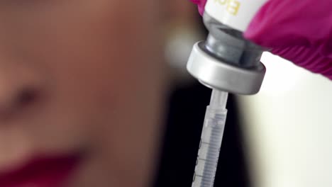 filling a syringe from a vial of medication - isolated close up