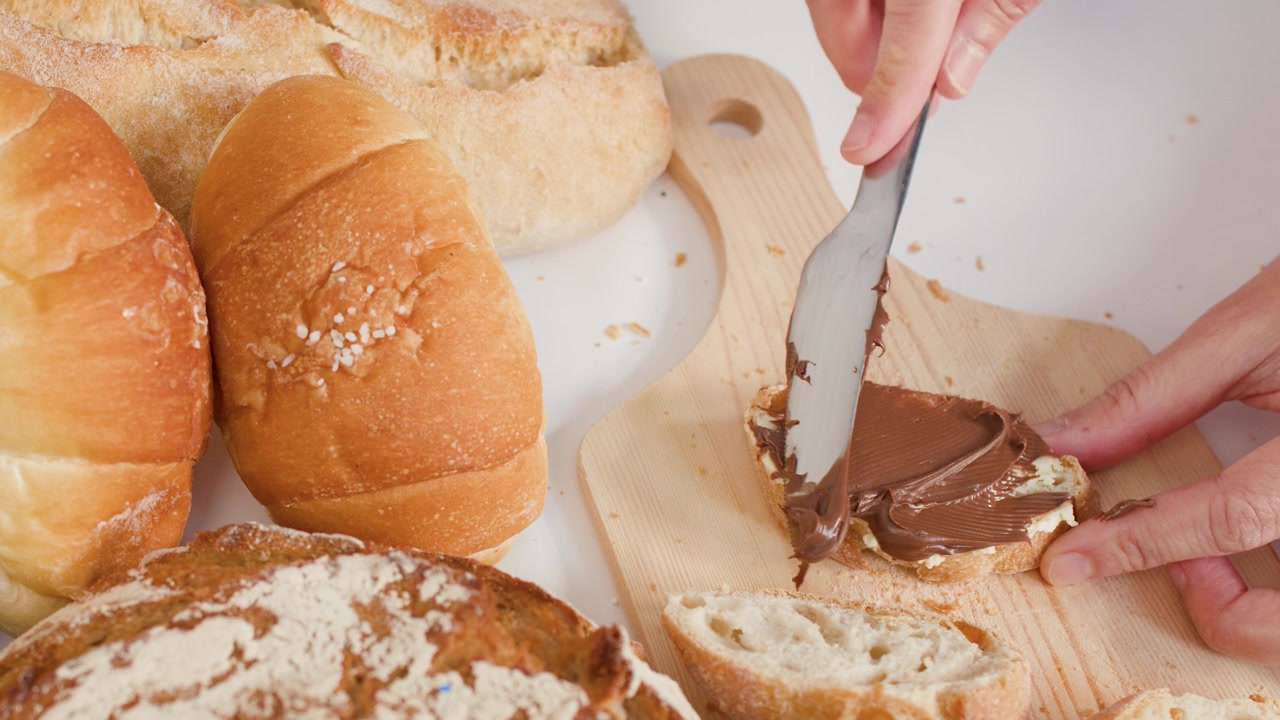 Spreading Chocolate Hazelnut Spread on a Slice of Bread