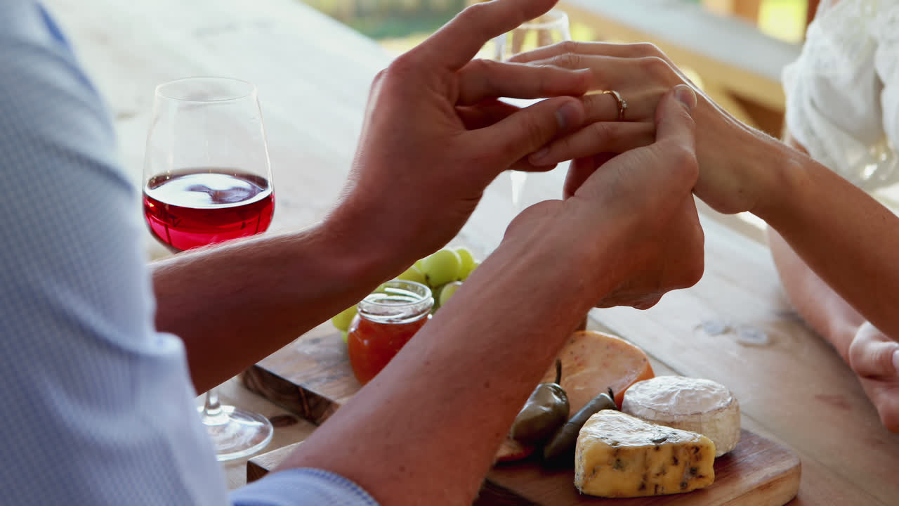 hombre sonriente llevando anillo de compromiso a una mujer 4k