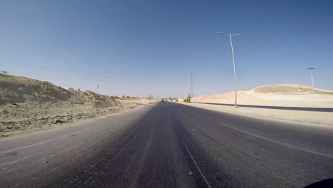 Punto-De-Vista-Trasero-Del-Coche-Conduciendo-Por-Una-Carretera-Del-Desierto-Y-Siendo-Perseguido-Por-Otros-Todoterrenos