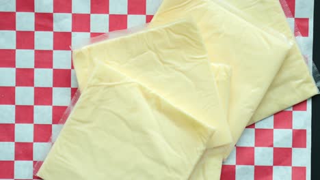 Transparent-packet-with-slices-of-cheese-on-yellow