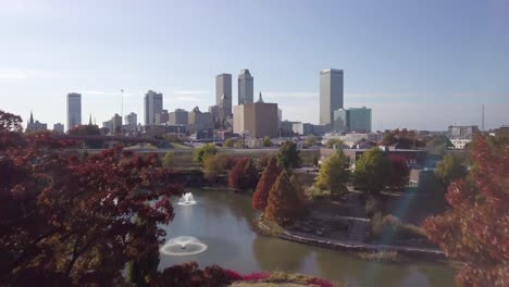 aerial drone footage of tulsa breaking through the trees in autumn