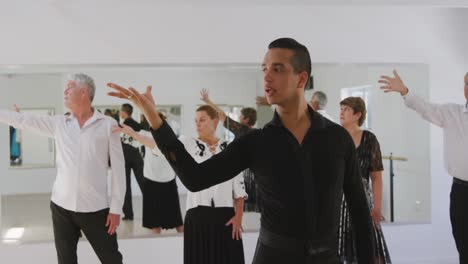 maestro de baile de raza mixta que toma una clase de baile de salón en un estudio de baile