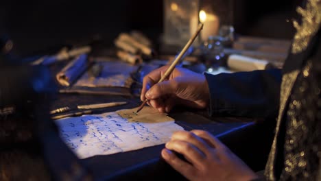 man writing in arabic by candlelight.