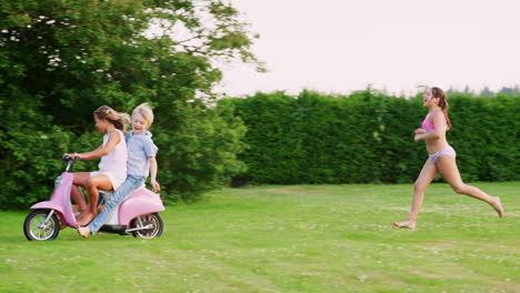 Pre-teen-kids-having-fun-in-garden-with-scooter-and-dog