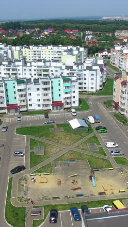 flying over the new built high-rise buildings and many roads for cars in the residential complex in summer. new area in the city with modern buildings in a sunny day. aerial view vertical video