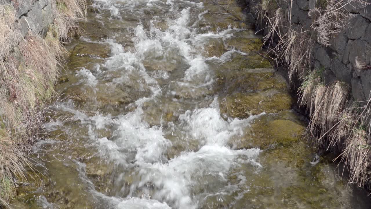 겨울의 한 날에 관개 운하를 따라 물이 흐릅니다.