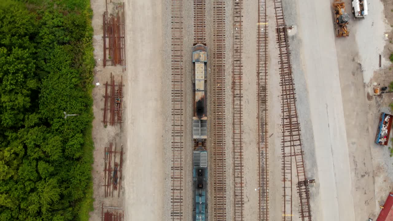 вид сверху вниз в формате 4k на локомотив поезда, который движется немного медленнее камеры, оставаясь в поле зрения