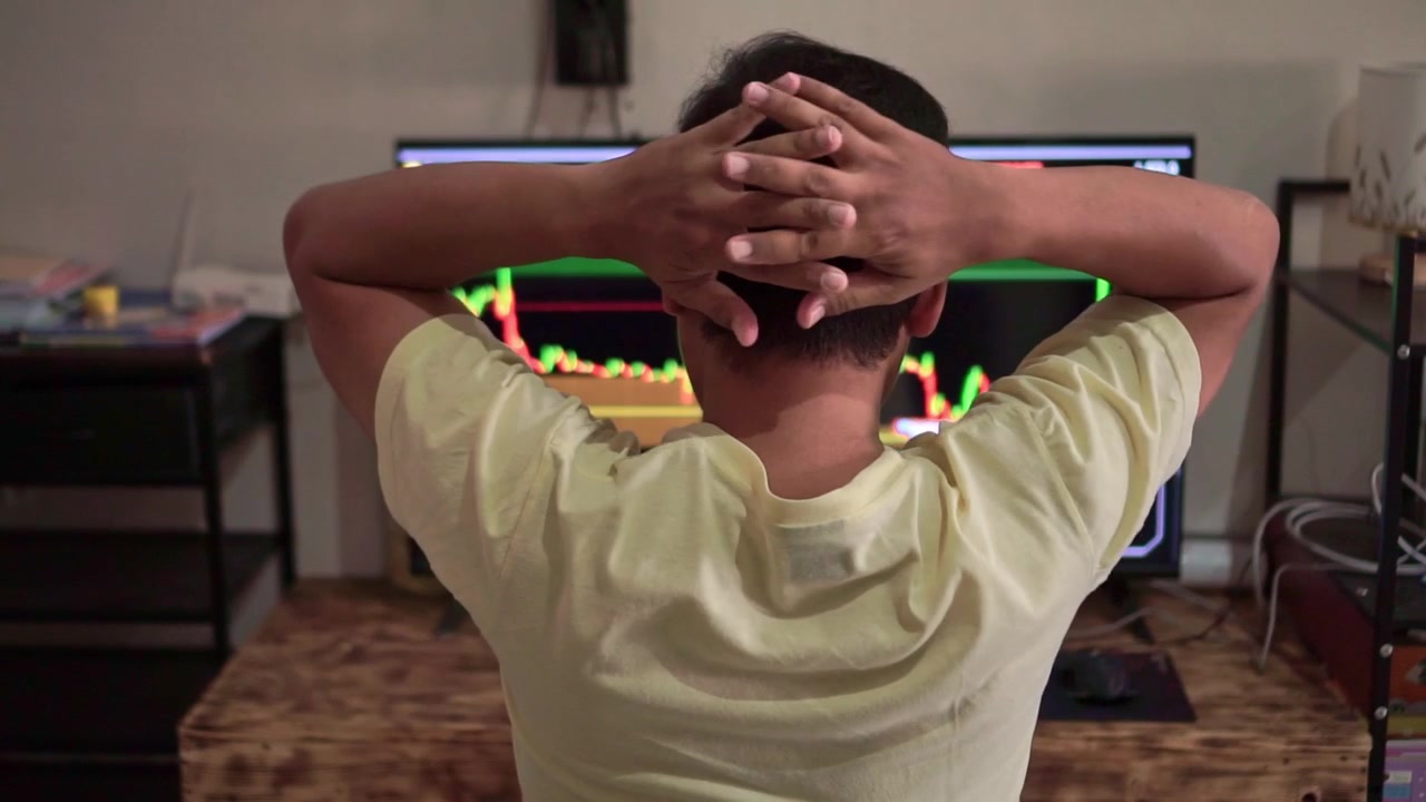 Back view of frustrated trader with hands on head, financial charts showing decline, stock market failure and investment stress concept.