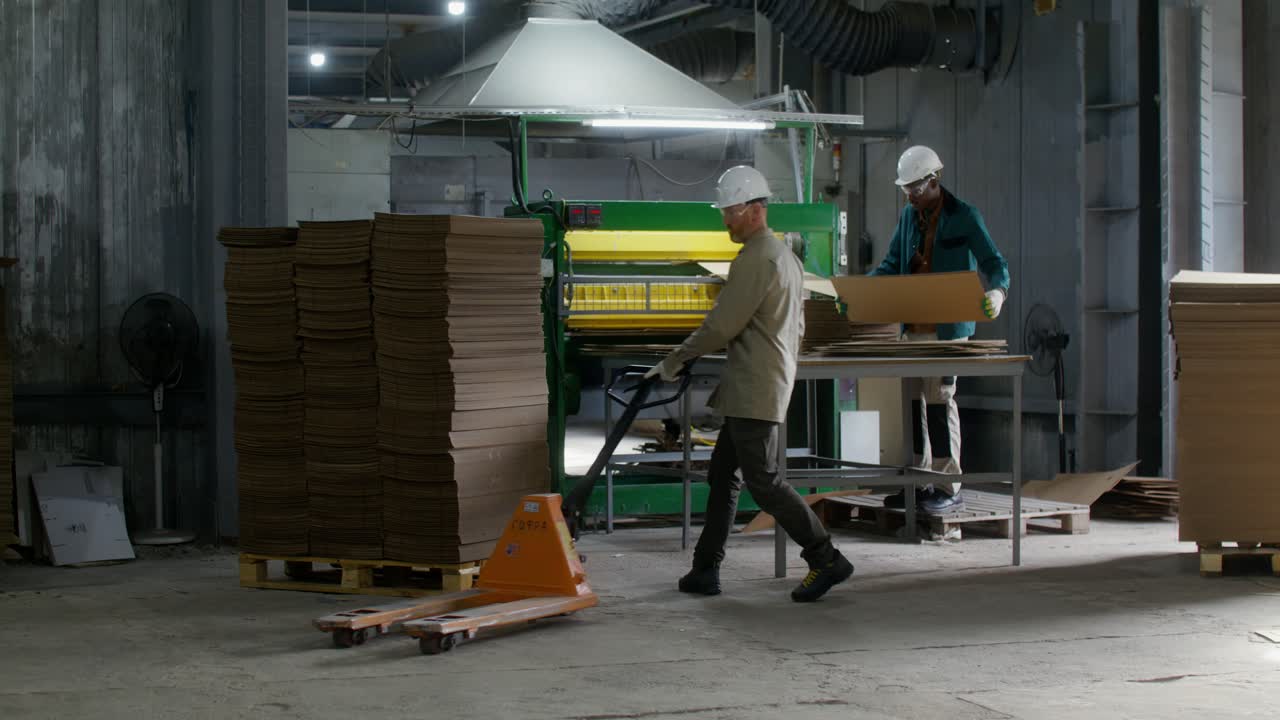 trabajadores de la fábrica que envasan cajas de cartón