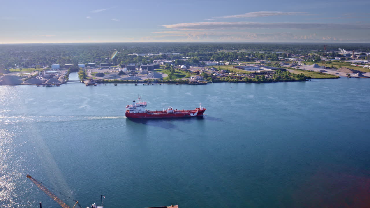 Cinematic drone shot of great lakes freighter cruising down the river