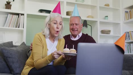 Feliz-Pareja-Caucásica-Mayor-Celebrando-Un-Cumpleaños-Haciendo-Videollamadas-Usando-Una-Computadora-Portátil
