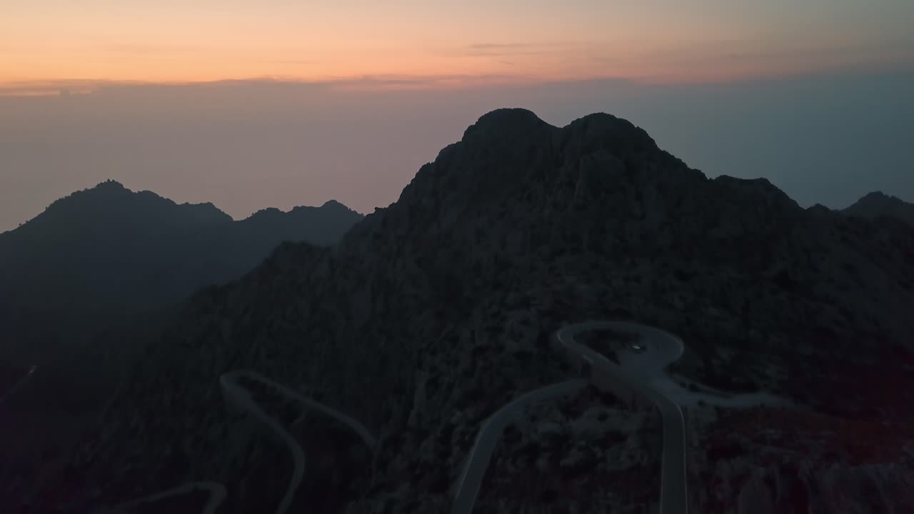 toma aérea inclinada hacia arriba del famoso camino serpenteante en nus de sa corbata durante el anochecer y la hora dorada