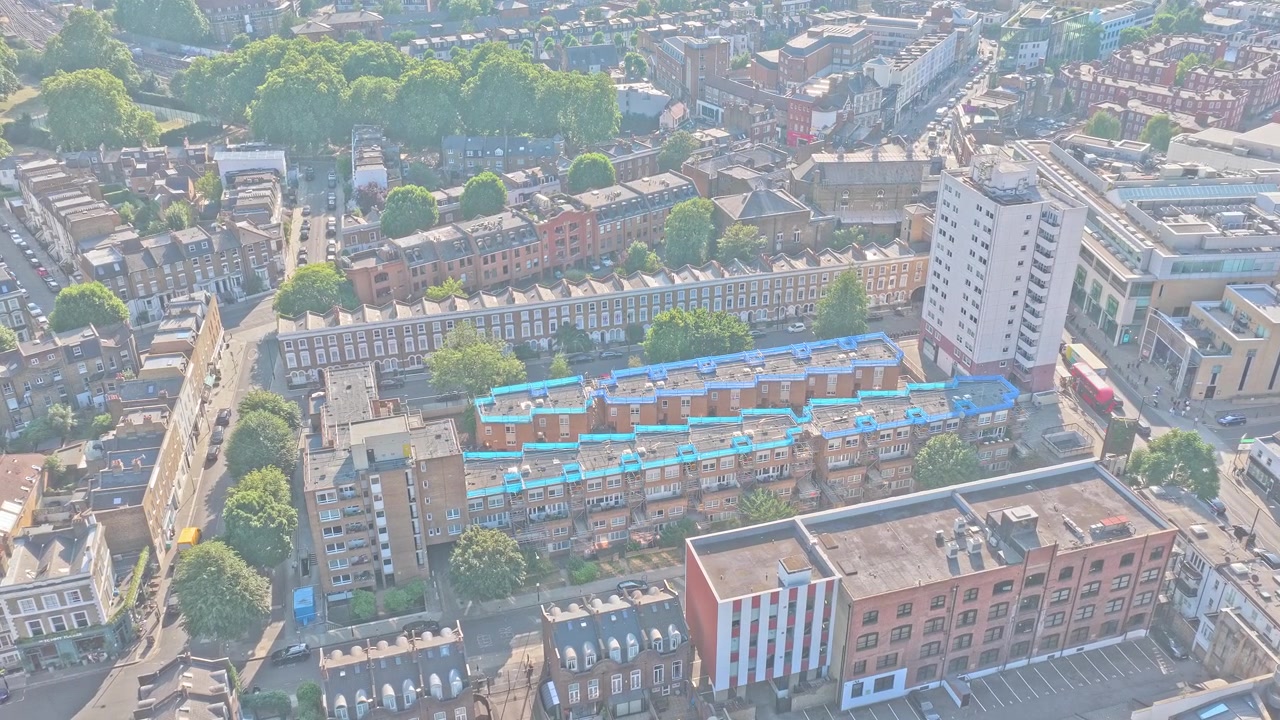 Aerial drone footage of the area surrounding Chelsea FC's Stamford Bridge Stadium in Fulham, West London, England. The daytime aerial footage captures the surrounding Residential streets.