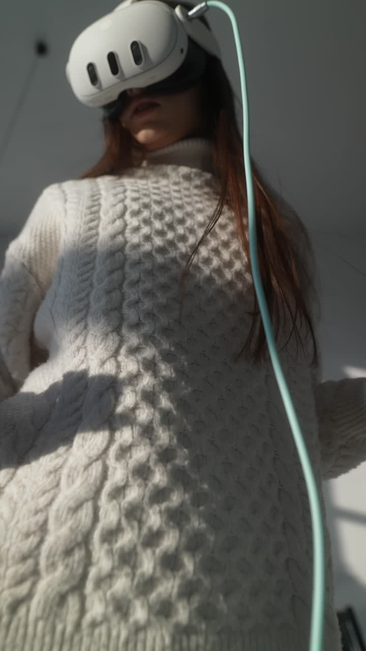 색 스웨터를 입고 가상 현실을 경험하는 여성