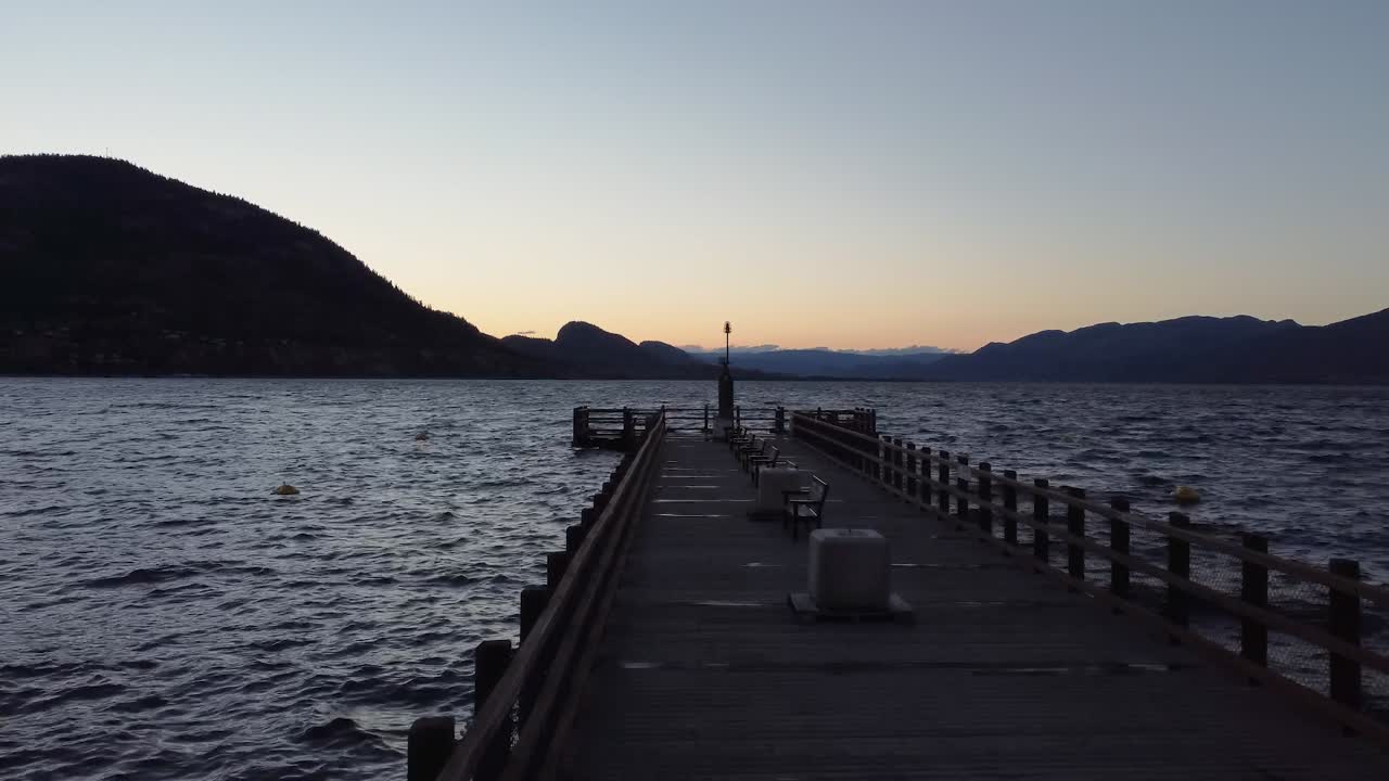 Drone flying over a long dock at sunrise in Penticton, British Columbia