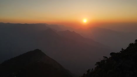 aerial drone shot of kolukkumalai range at daybreak, surrounded by lush greenery and mist