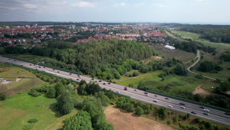 Aerial-drone-over-highway,-cars-driving-to-and-from-city