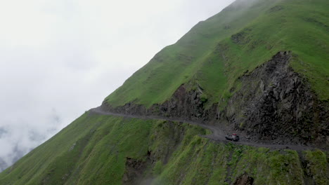 Toma-Cinematográfica-De-Un-Vehículo-Conduciendo-Al-Borde-De-Un-Acantilado-En-El-Camino-A-Tusheti,-Uno-De-Los-Caminos-Más-Peligrosos-Del-Mundo