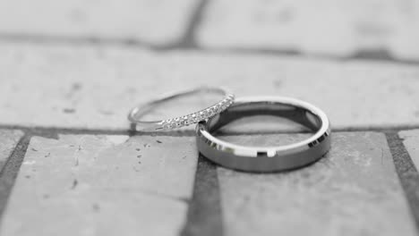 elegant wedding bands or rings with diamonds laid out on a gorgeous stone table top