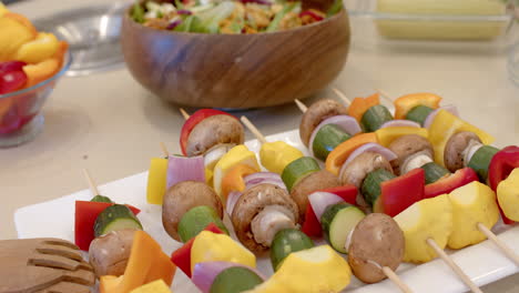 arranged on kitchen counter, colorful vegetable skewers with fresh salad for meal, at home