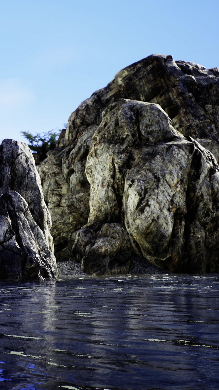 Rocks and water create a natural scene near the shore in bright sunlight