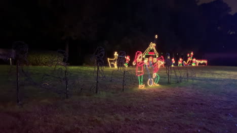 night shot of christmas lights of elves on a wheelbarrow