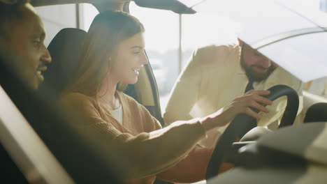 couple test driving a car at dealership