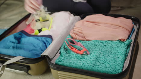 mujer empaca ropa para vacaciones 1