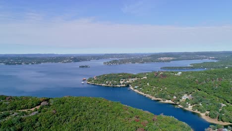 drone footage of trees and lakes on a beautiful sunny day rising and pulling back