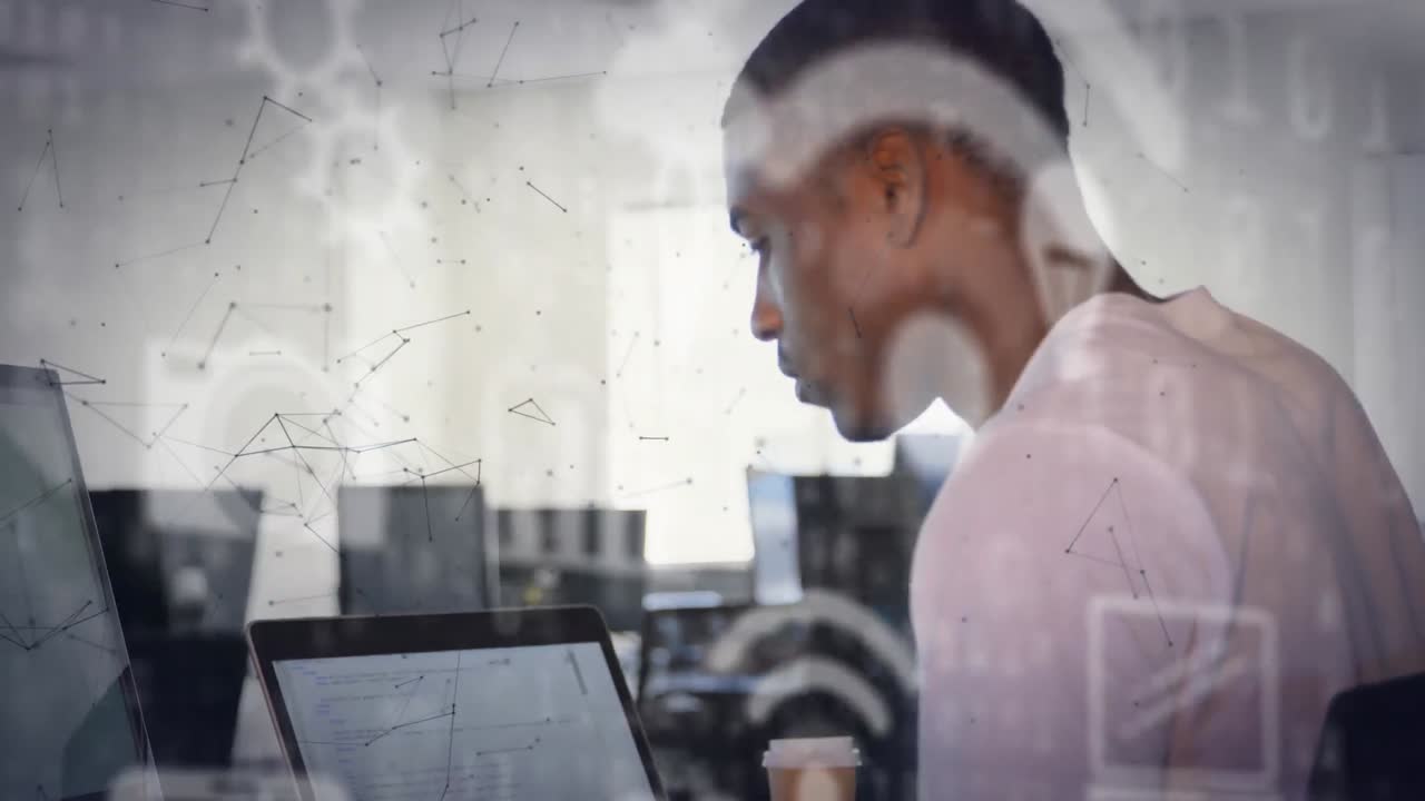 Animation of icons and connections over african american businessman using laptop in office