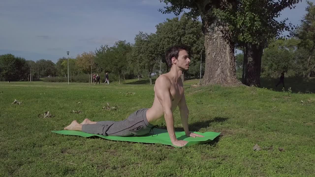 hombre feliz sonriente haciendo yoga y estiramiento en el parque, estilo de vida de la naturaleza loto