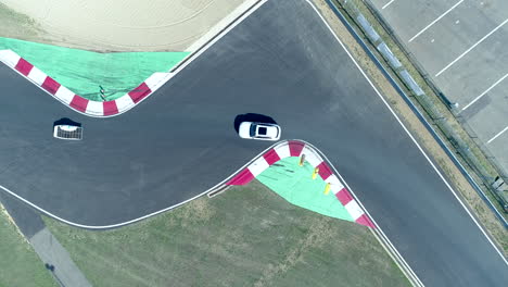 Brand-New-Solar-Car-Driving-On-The-Race-Track-Curved-Road-Followed-By-A-White-Car