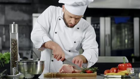 Male-chef-cutting-meat-slice-at-professional-kitchen.-Chef-preparing-beef