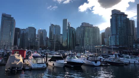 Marina-of-Vancouver-filled-with-a-lot-of-pleasure-yachts-with-skyscrapers-of-glass-on-a-cold-and-sunny-winter-day