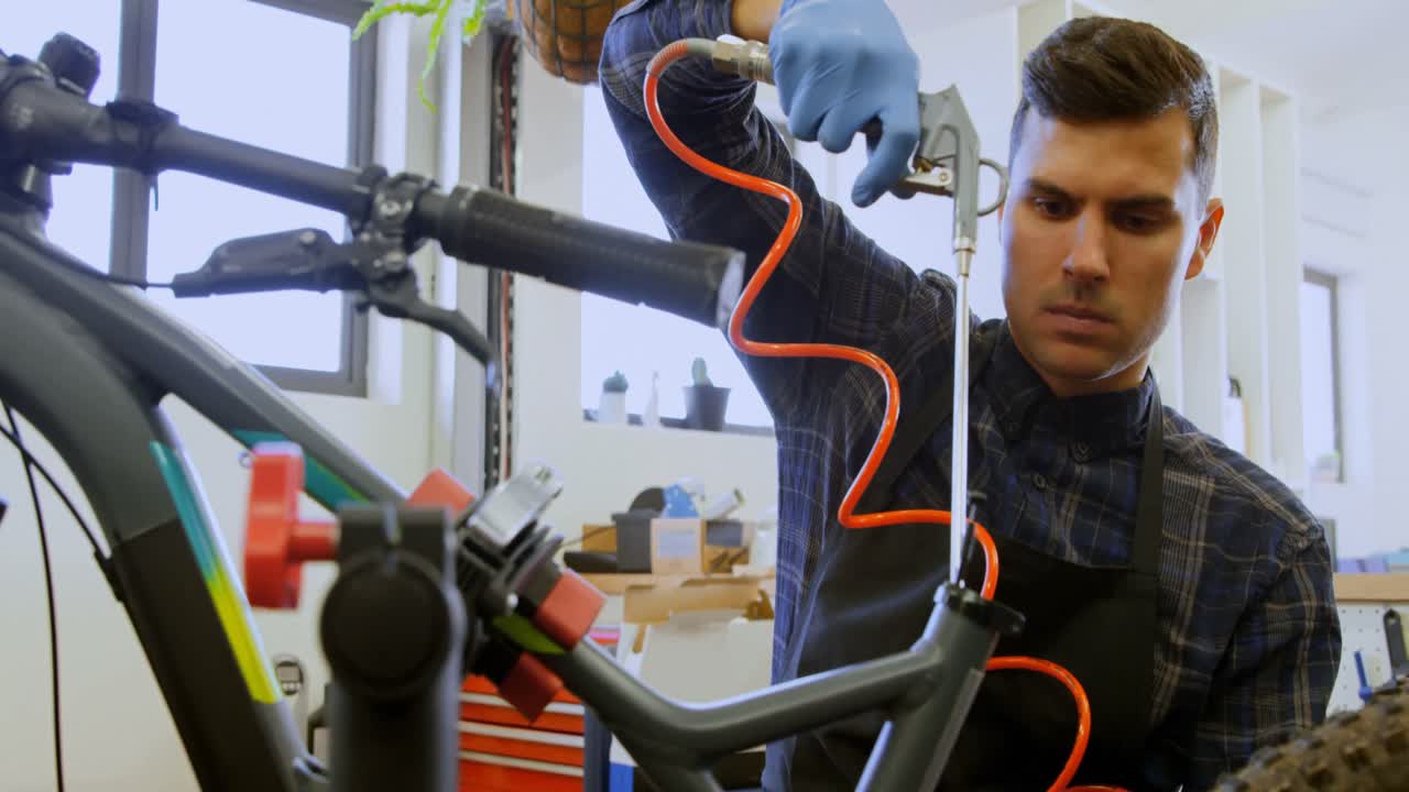 hombre reparando una bicicleta en el taller 4k