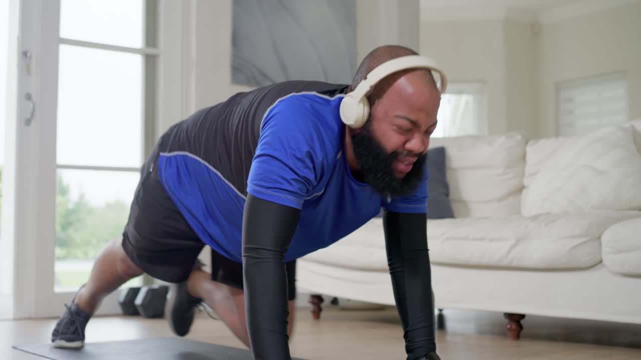 African American man in gym gear leaning on mat doing climbers for workout holding kneeling stretch