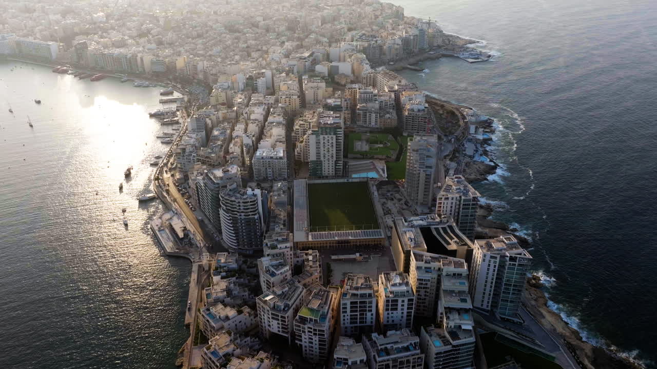 tomada aérea de la inclinación frente al punto de tigne, puesta de sol de verano en sliema, malta