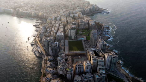 Aerial-tilt-shot-in-front-of-the-Tigne-Point,-summer-sunset-in-Sliema,-Malta