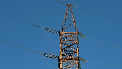 Power-lines-with-sun-rays-on-blue-sky