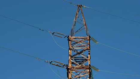 líneas eléctricas con rayos de sol en el cielo azul