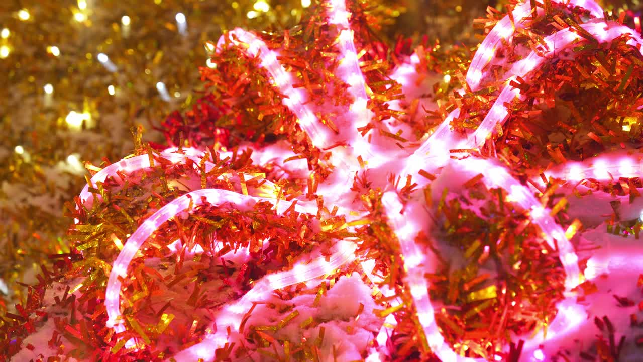 다채로운 반이는 크리스마스 장식. 거리의 클로즈업에서 네온 빛나는 박이는 장식. 새해 축하. 밤 마을에서 겨울 휴가 축하. 4k 영상