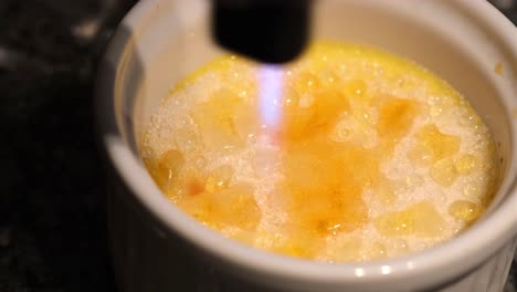 burn portion of french dessert cream brulee in close up 4k