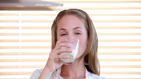una mujer joven bebiendo leche.