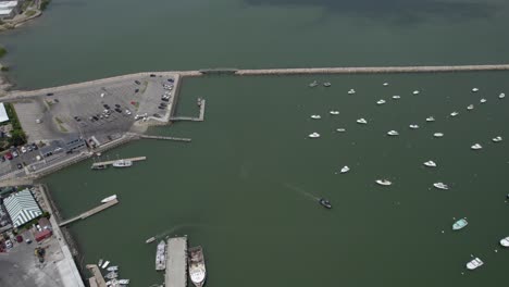 vista aérea con vistas al puerto y muchos barcos anclados en la soleada plymouth, ee.uu. - seguimiento, inclinación, disparo de drones