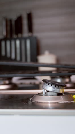 woman's hand cleaning metal cooker. cleaning gas stove in the kitchen. pure surface of a gas cooker. householding concept. close-up. vertical video