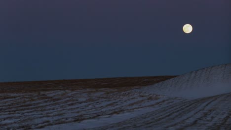 super moon over top of a snowy field