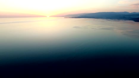 estudio aéreo del paisaje marítimo con vistas a la puesta de sol en el horizonte.