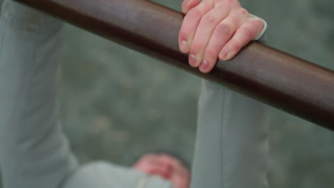 close-up of a young boy gripping an iron bar during a workout session, with a blurred view of the boy s face and surroundings